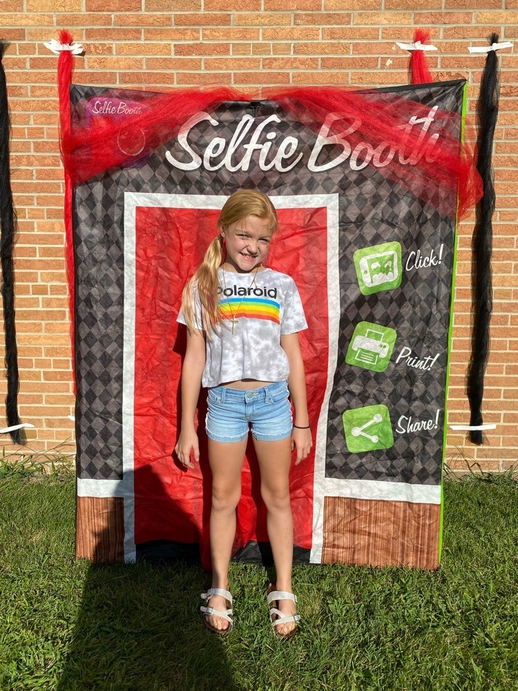 student standing in front of photo booth