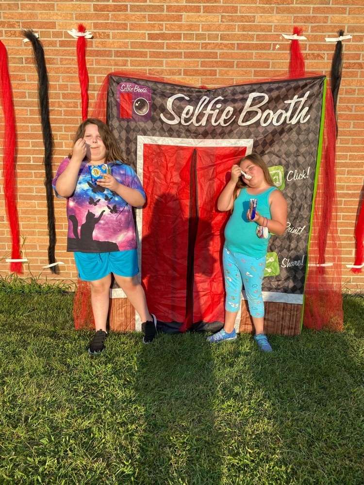 two students standing in front of photo booth