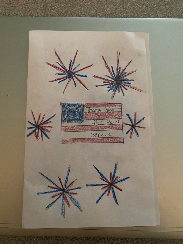 a Veterans Day card with a student drawing of an American flag and fireworks 