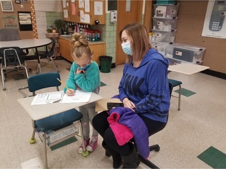 a student completing a word search with her mother